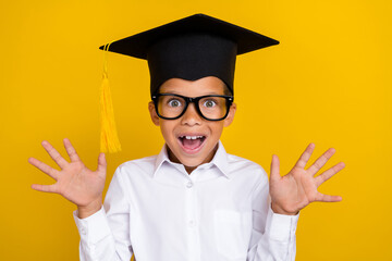 Portrait of surprised astonished boy raise opened hands unbelievable isolated on yellow color...