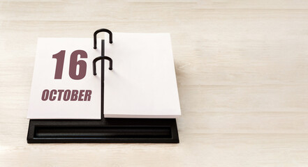 october 16. 16th day of month, calendar date. Stand for desktop calendar on beige wooden background. Concept of day of year, time planner, autumn month