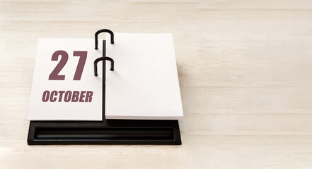 october 27. 27th day of month, calendar date. Stand for desktop calendar on beige wooden background. Concept of day of year, time planner, autumn month