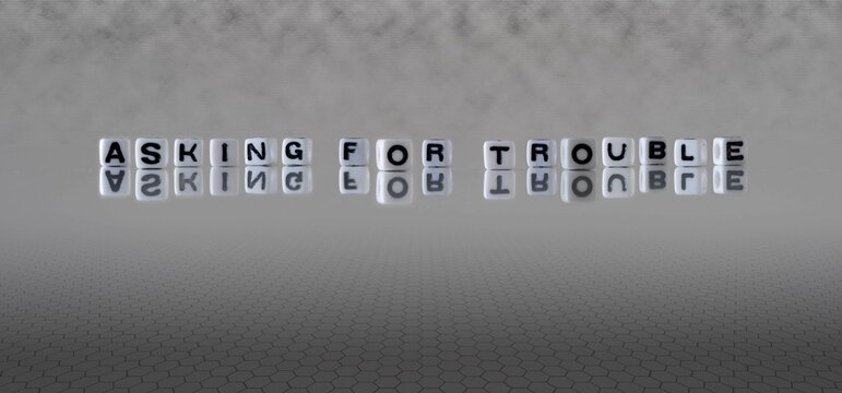 asking for trouble word or concept represented by black and white letter cubes on a grey horizon background stretching to infinity