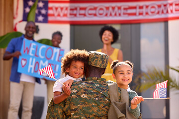 Multi-Generation Family Welcoming Army Father Home On Leave With Banner