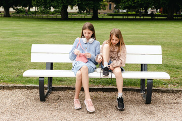 Two girls are sitting on a park bench