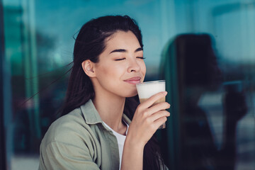 Photo of dreamy sweet girlfriend wear green outfit sitting cafe tasting ice latte outdoors city residential complex