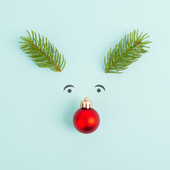 Face of a reindeer with a red bauble nose, fir antlers and friendly eyes, merry christmas greeting...