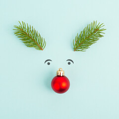 Face of a reindeer with a red bauble nose, fir antlers and friendly eyes, merry christmas greeting card
