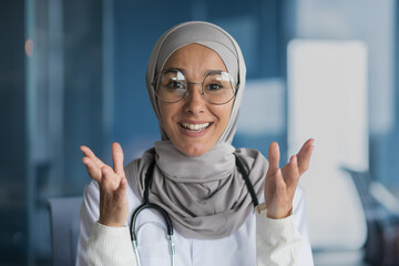 Webcam view, arab female doctor in hijab smiling and talking on video call, pediatrician talking...