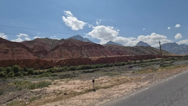 Amazing summer mountain landscape of Kyrgyzstan from the side window of a moving car. On the way to Lenin Peak.