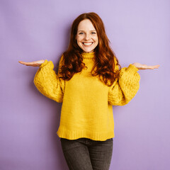 laughing redhead woman holding her hands up, copyspace with purple background