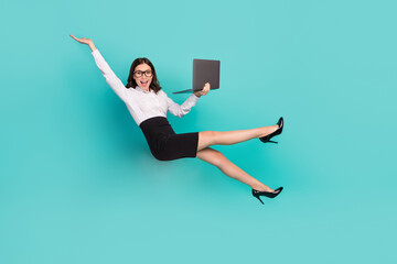 Full body photo of excited crazy lady hold use wireless netbook falling isolated on emerald color...