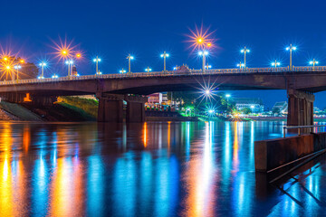 Beautiful lights water reflection full of banks of the Nan River at night on the bridge (Naresuan Bridge)at night in the park in Phitsanulok City,Thailand.
