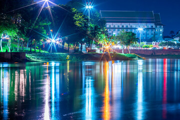 Beautiful lights water reflection full of banks of the Nan River at night on the bridge (Naresuan Bridge)at night in the park in Phitsanulok City,Thailand.