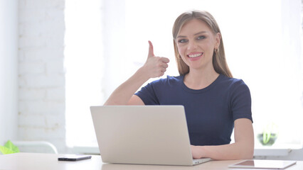 Woman Showing Thumbs Up While using Laptop