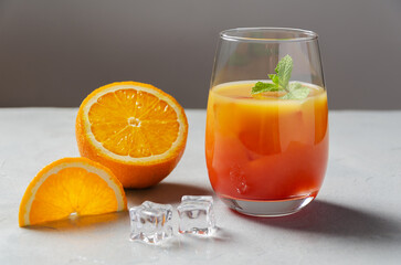 Classic Garibaldi alcoholic cocktail with campari, orange juice, ice and slice of orange or mocktail on a background