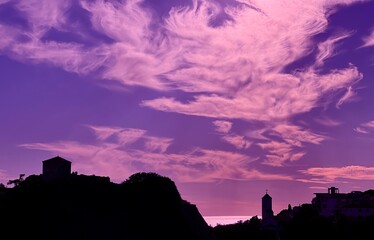 Obraz premium Dark silhouette old town against impressive sunset sky clouds.