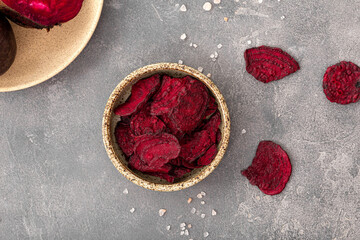 Beetroot chips in a bowl on a gray background. Healthy vegetable chips, snack for vegetarians top view