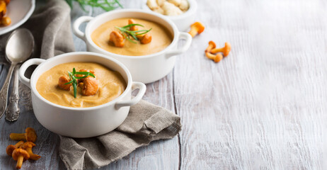 Mushroom Cream Soup with Shanterelles and Herbs, White Wooden Table