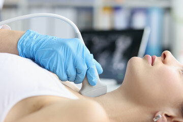 Woman receives ultrasound of thyroid gland from doctor