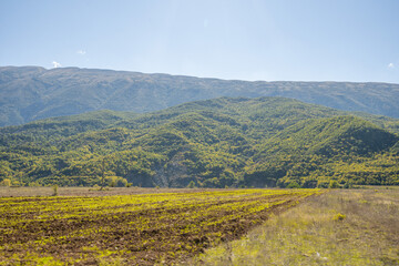 Obraz premium plowed field against the background of mountains in Albania. Agricultural landscape