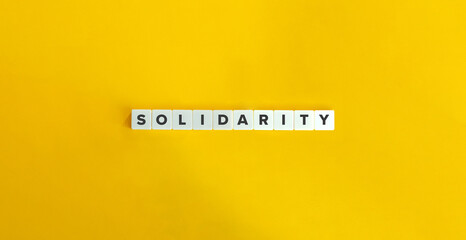 Solidarity Word on Block Letter Tiles on Yellow Background. Minimal Aesthetics.