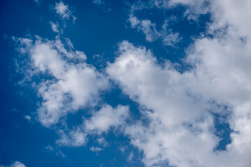 Natural sunny blue sky background with beautiful puffy white cumulus clouds