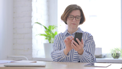Senior Woman using Smartphone in Office