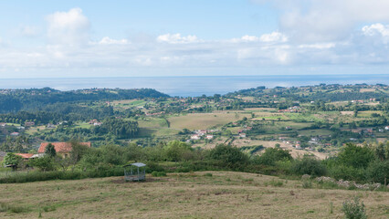 Fototapeta na wymiar Granjas y casas rurales en valle verde junto al mar