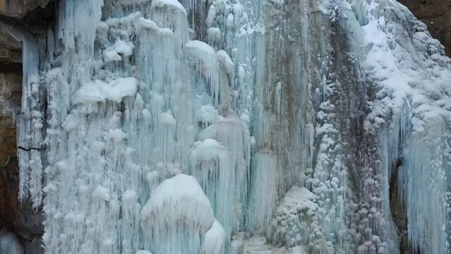 Frozen waterfall view close up view, aerial footage. Professional drone's camera slowly move from top to down. frozen water, close up view. Frozen Waterfall in Armenia, Western Asia.
