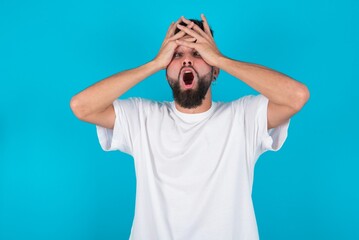 Horrible, stress, shock. Portrait emotional crazy bearded caucasian man wearing white T-shirt over...