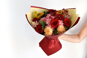 Beautiful flowers for holiday. Woman with beautiful flowers in  hands indoors background.  bouquet of flowers for  flower shop.