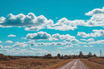 Landscape In The Countryside - Rural Road, Field And Picturesque Blue Sky With Clouds.
