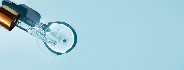 Pipette and transparent gel-like liquid on a blue background. Top view, place for text. Banner with place for text.