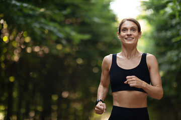 Happy blonde lady jogging by public park