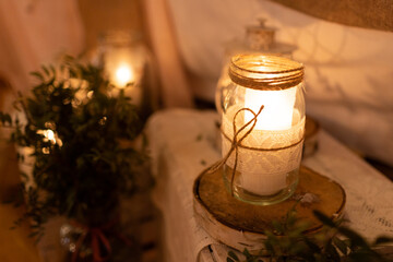 Boho wedding decoration. Rustic decorations of wedding venue. Romantic atmosphere. Wooden box and white candles. Vintage style interior. Wedding party in a barn.