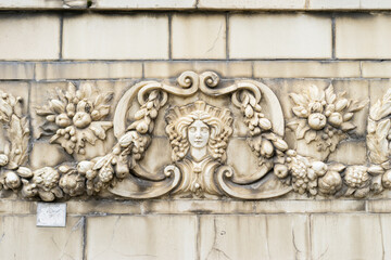 The facade of an old building decorated with a pattern of stucco. Mythical creatures on the facade of an old house.