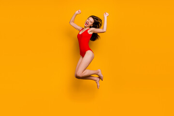 Fototapeta na wymiar Full body photo of delighted excited person jump raise fists celebrate success isolated on yellow color background