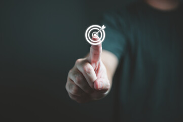 Businessman hand touching target dartboard to setup goal and achievement objectives for business investment. Business financial and startup concept.