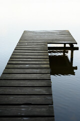 Obraz premium wooden footbridge on lake with reflection on lake in Germany
