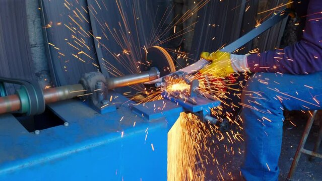 Close-up view of blacksmith sharpening a sword.