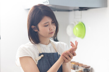 キッチンで手荒れを気にする女性