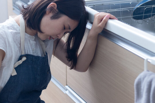 料理中につわりで苦しむ女性