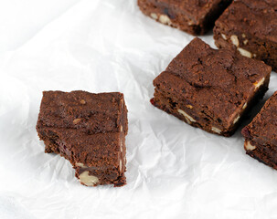 Chocolate homemade brownies with dried cranberries and walnuts on the white  background