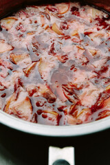 Plum and apple jam. Cooking cooking jam in a frying pan. Homemade jam with sugar syrup. The process of cooking, boiling berries for canning.Close-up top view