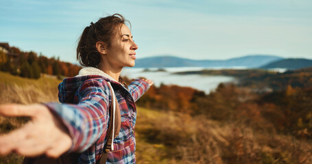 Young beautiful hiker woman admiring nature view opening arms into the sky on mountain range - 528942086