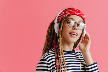 White woman with dreadlocks laughing while listening music