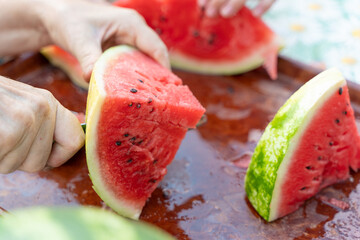 Cut a red watermelon into pieces with a knife