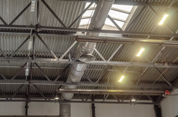 The ceiling of a large factory building with artificial lighting. Industrial background.