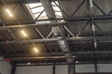 The ceiling of a large factory building with artificial lighting. Industrial background.