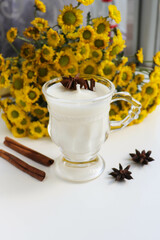 original candle made of natural soy wax in a glass goblet and bouquet of flowers