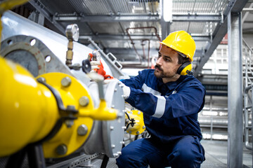 Refinery operator standing by pipes and controlling natural gas supply and distribution.