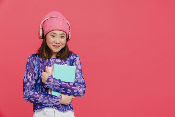 Young cute asian girl in pink winter hat and headphones